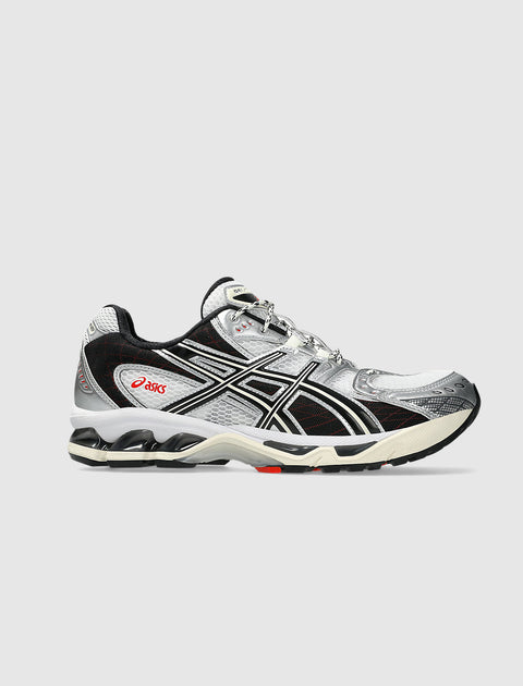 White and black men's sneaker with mesh panels, silver accents, and red logo detailing