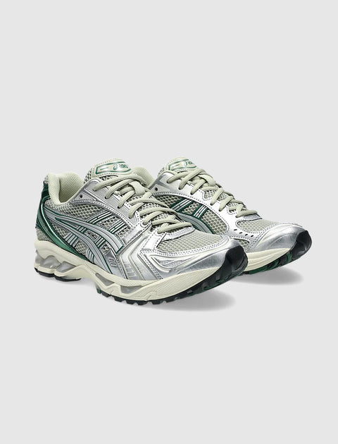 Silver and green mesh running sneakers with textured sole on a light grey background