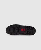 Black rubber sneaker sole with rugged tread and red accent on a light background