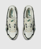Top view of white and black mesh sneakers with green logo accents on insoles