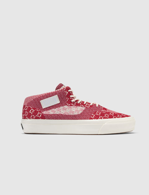Red and white knit mid-top sneaker with white sole and laces, side profile view