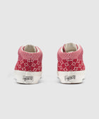 Back view of red and white knit high-top sneakers with white soles on a plain background