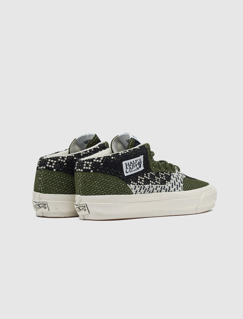 Pair of olive green and black knit skate shoes with geometric check pattern, white soles
