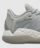 Closeup of a grey low-top sneaker with wavy textured white sole and mesh heel panel