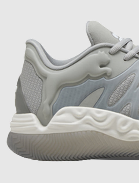 Closeup of a grey low-top sneaker with wavy textured white sole and mesh heel panel