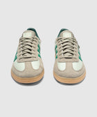 Mint green and beige suede low-top sneakers with green stripes and gum soles, front view