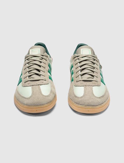 Mint green and beige suede low-top sneakers with green stripes and gum soles, front view