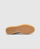 Gum sole of sneaker with circular tread pattern and adidas logo on white background