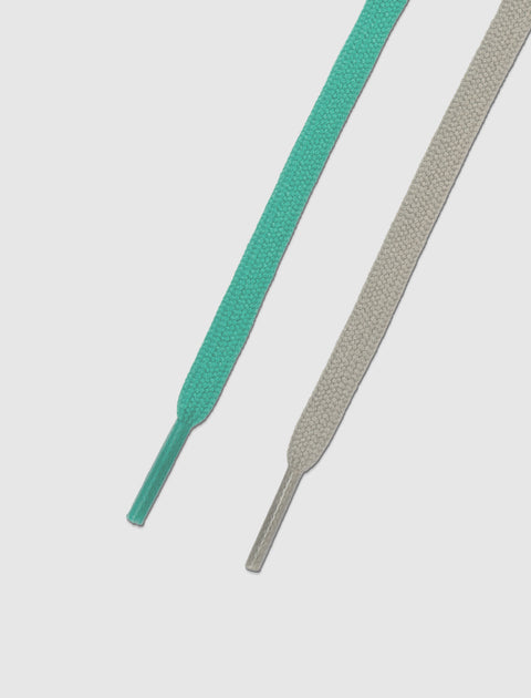 Mint green and beige sneaker laces on white background, close-up detail