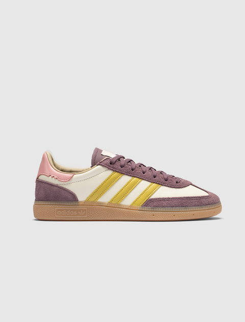 Purple, pink, and yellow suede sneaker with gum sole on white background