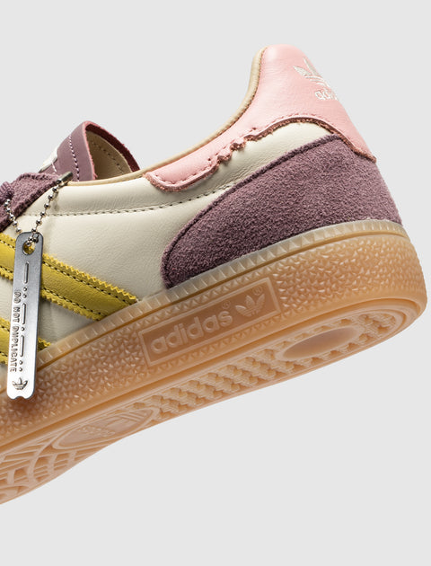 Adidas sneaker with pastel purple, yellow, and pink accents and gum sole close-up