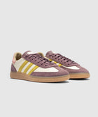 Purple, yellow, and cream low-top sneakers with gum soles on a plain background.