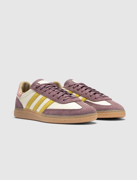 Purple, yellow, and cream low-top sneakers with gum soles on a plain background.