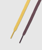 Closeup of yellow and purple flat sneaker laces on a white background