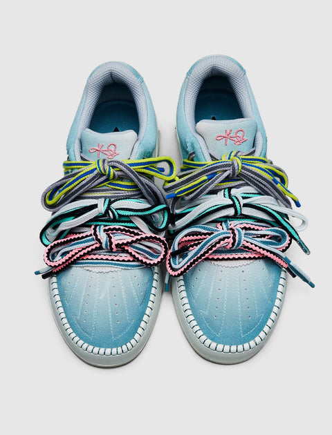 Light blue sneakers with multicolor laces and pink, blue, and grey accents, viewed from above.