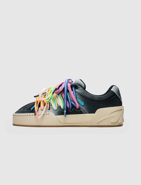 Black low-top sneaker with beige sole and multi-color rainbow laces on white background