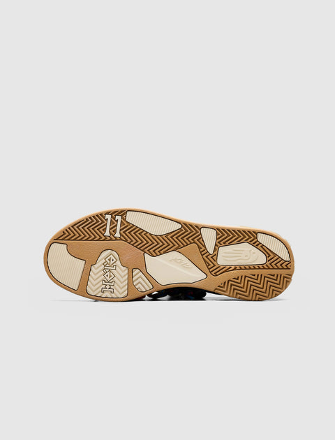 Close-up of sneaker sole with gum and cream tread, featuring textured grip patterns.