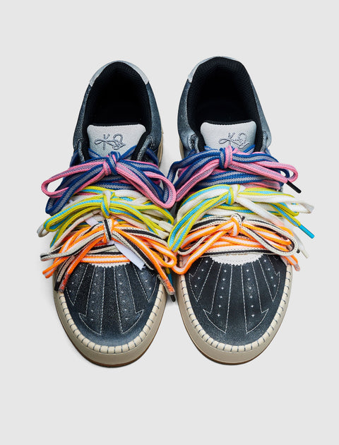 Pair of dark blue sneakers with white toes and multiple colorful shoelaces.