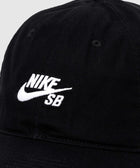 Black Nike SB cap with white embroidered logo, close-up view