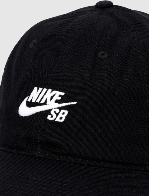 Black Nike SB cap with white embroidered logo, close-up view