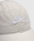 Beige cotton baseball cap with embroidered white Nike SB logo on front