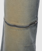 Close-up of stone-washed denim pants with a horizontal zipper detail on the thigh.