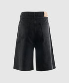 Back view of black denim men's shorts with patch pockets on a light background