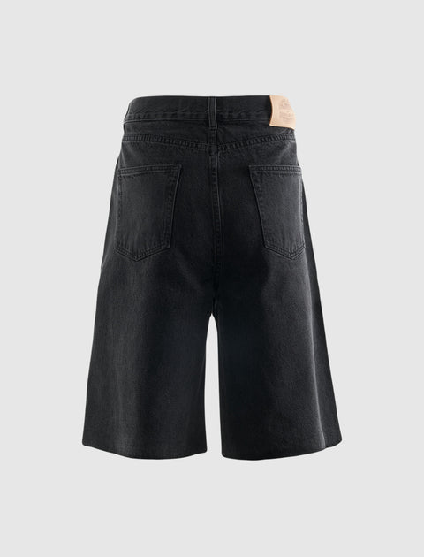 Back view of black denim men's shorts with patch pockets on a light background