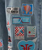Blue denim fabric with colorful embroidered patches and streetwear-inspired designs