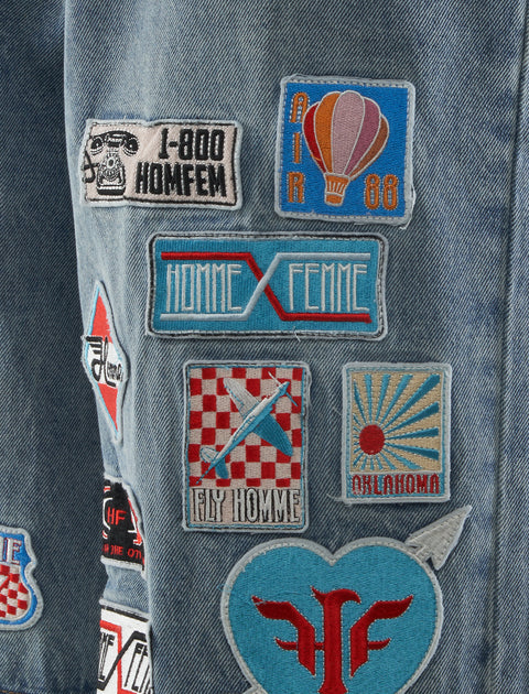 Blue denim fabric with colorful embroidered patches and streetwear-inspired designs