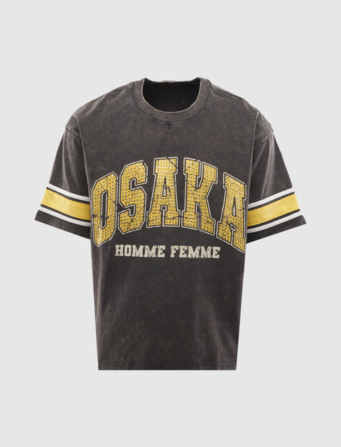 Black graphic streetwear t-shirt with yellow 'Osaka' print and varsity stripes on sleeves.