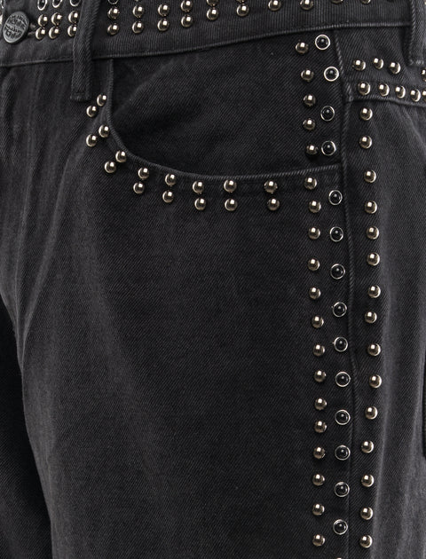 Closeup of black denim jeans with metallic stud detailing along pocket and seam