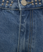 Close-up of blue denim jeans with metal studs and button details