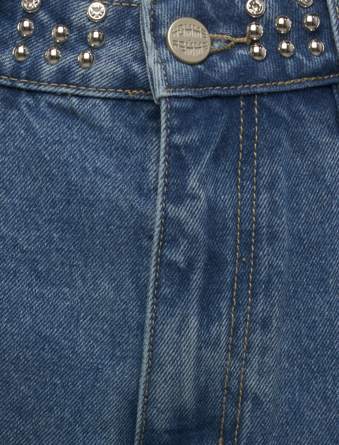 Close-up of blue denim jeans with metal studs and button details
