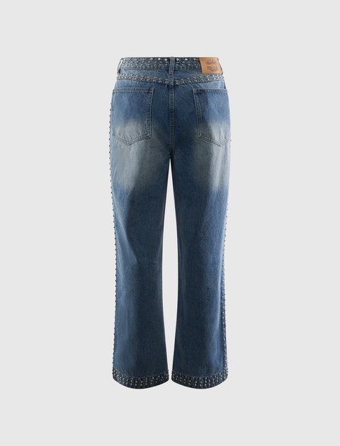 Back view of blue denim jeans with silver stud embellishments on waistband, side seams, and cuffs