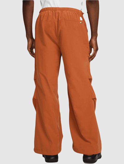 Back view of men's orange wide-leg pants with elastic waistband, streetwear style