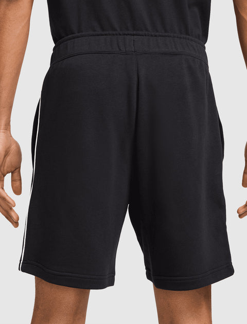 Back view of men's black athletic shorts with white side stripes, elastic waistband
