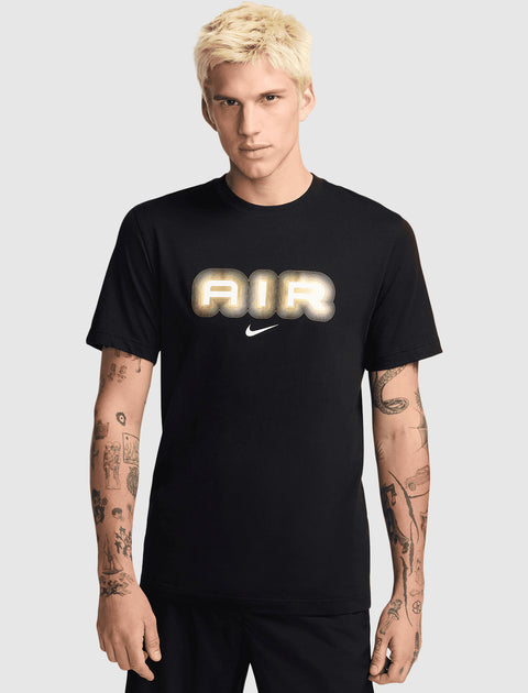 Man wearing a black graphic tee with 'AIR' and swoosh, streetwear style, tattooed arms