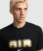 Man wearing black t-shirt with metallic gold and white AIR graphic and Nike logo