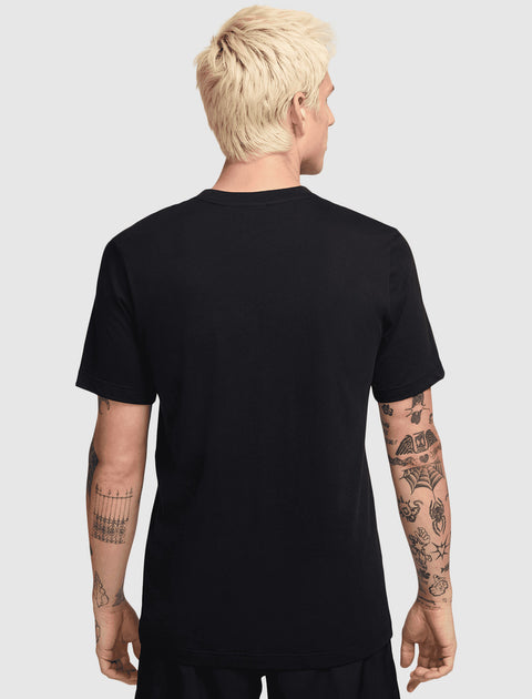 Back view of man in black short sleeve streetwear t-shirt with visible arm tattoos