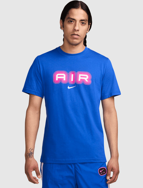 Man wearing blue t-shirt with pink AIR graphic and Nike logo, blue shorts, neutral background