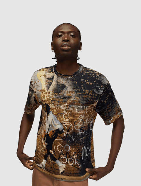 Man wearing graphic streetwear t-shirt with urban graffiti and brick wall print