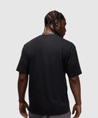 Back view of man in black short sleeve streetwear t-shirt and gray shorts