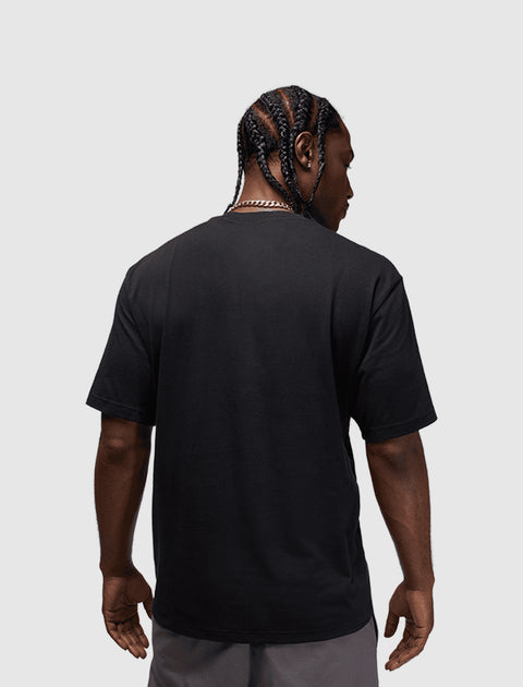 Back view of man in black short sleeve streetwear t-shirt and gray shorts