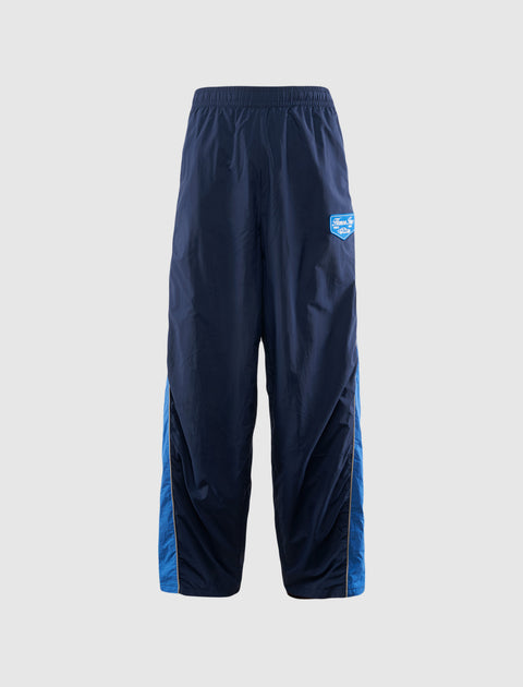 Men's navy blue track pants with elastic waistband and blue side panels on white background