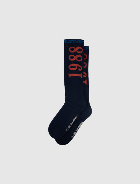 Navy crew socks with bold red '1988' text and white lettering, streetwear accessory