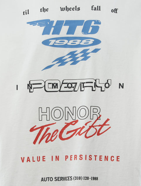 White streetwear graphic tee with blue, black, and red racing-inspired text and bold lettering.