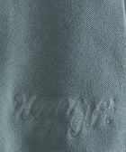 Green textured fabric with 'Honor the Gift' embroidered in matching thread