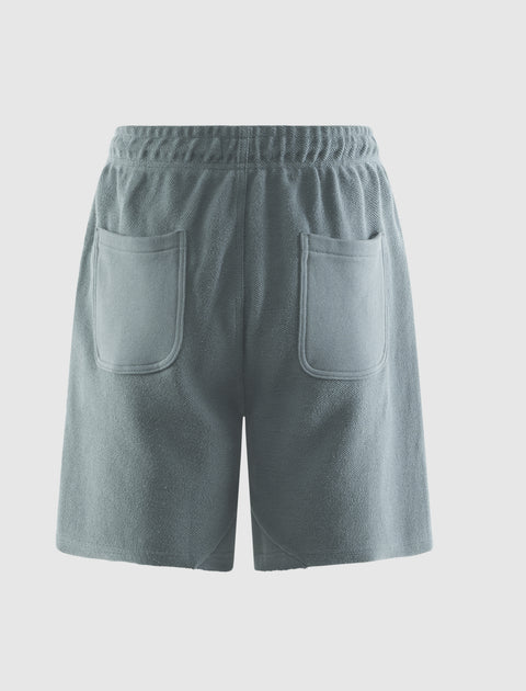 Back view of green men's streetwear shorts with elastic waistband and two rear pockets
