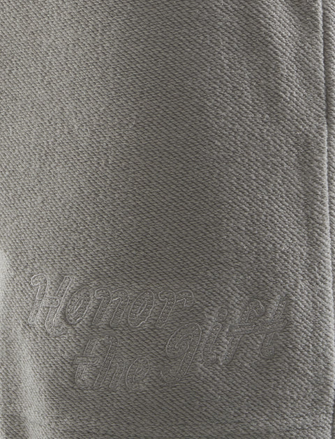 Close-up of grey textured fabric with 'Honor the Gift' embroidered text